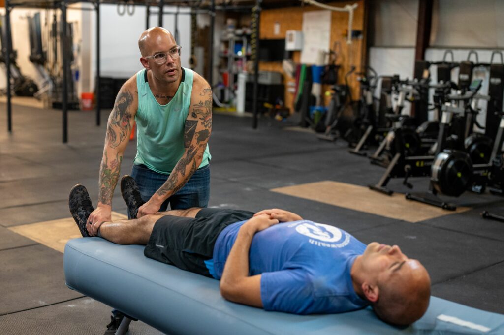 Jeff working on a client in a gym.