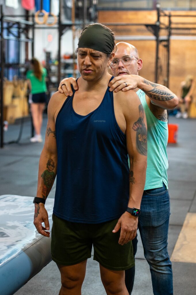 Jeff works on a standing client in a gym